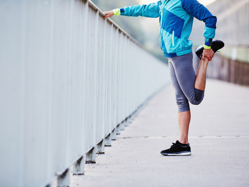 Woman stretching her leg before running